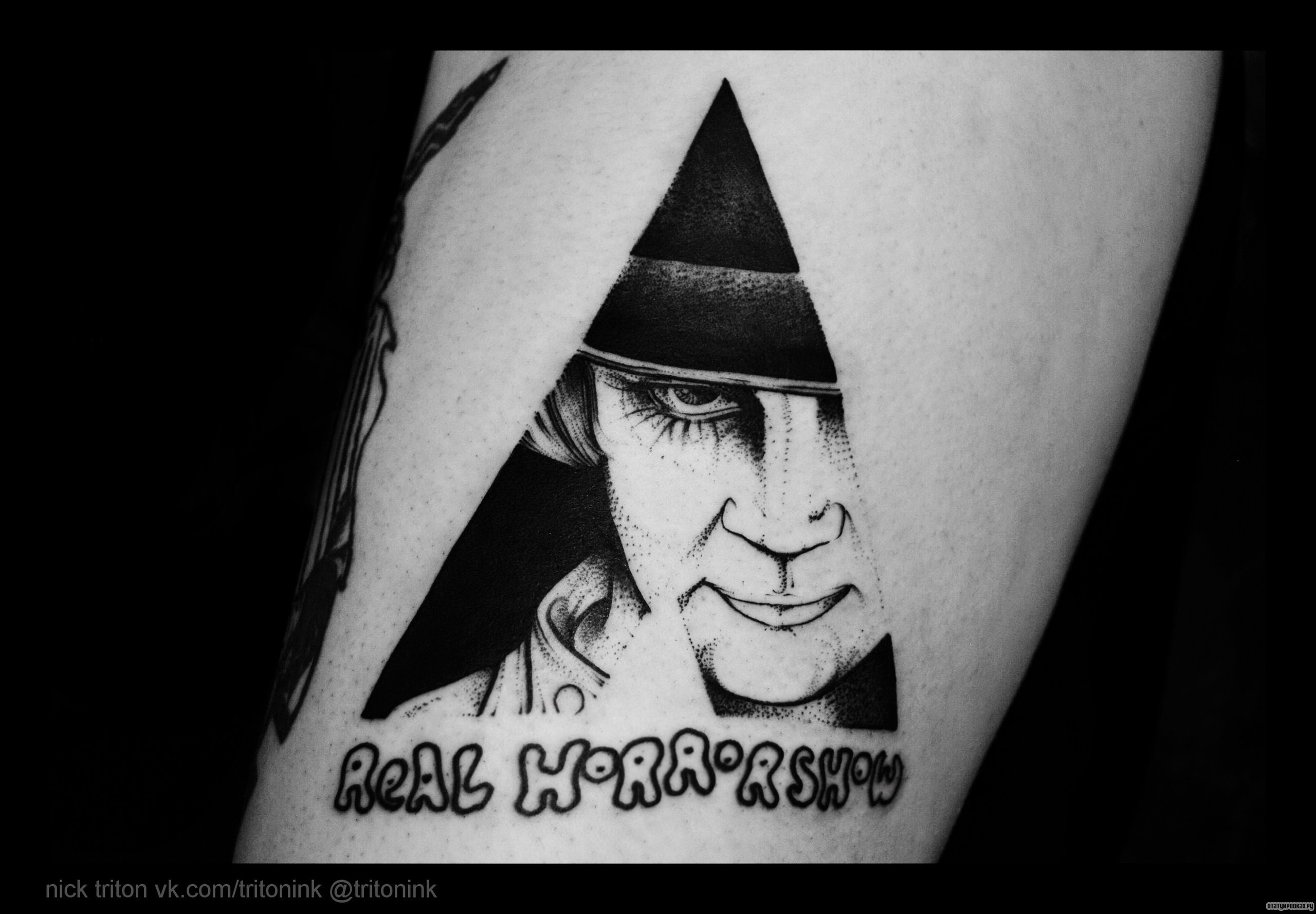 Фотография татуировки под названием «Человек в треугольнике и надпись»