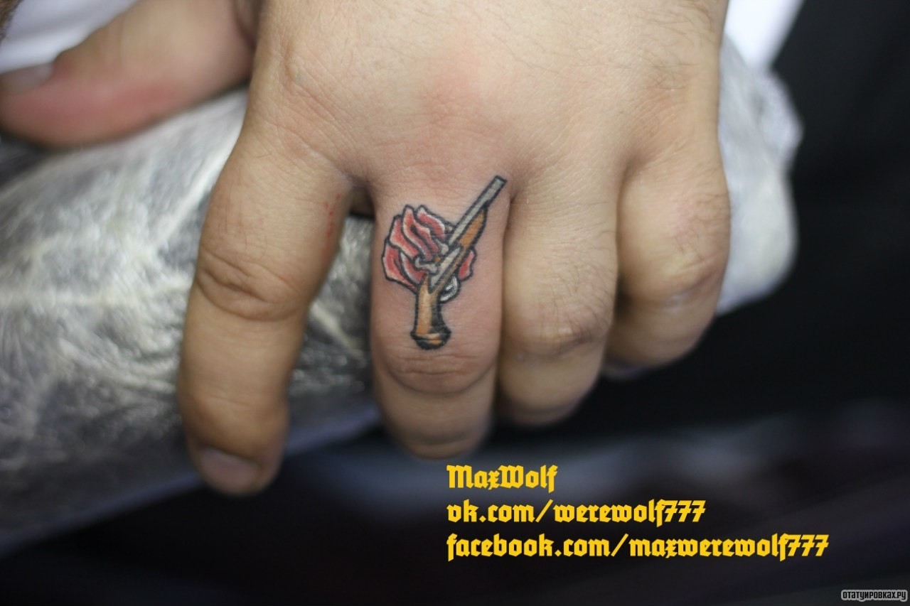 Фотография татуировки под названием «Пистолет и розочка на пальце минимализм»