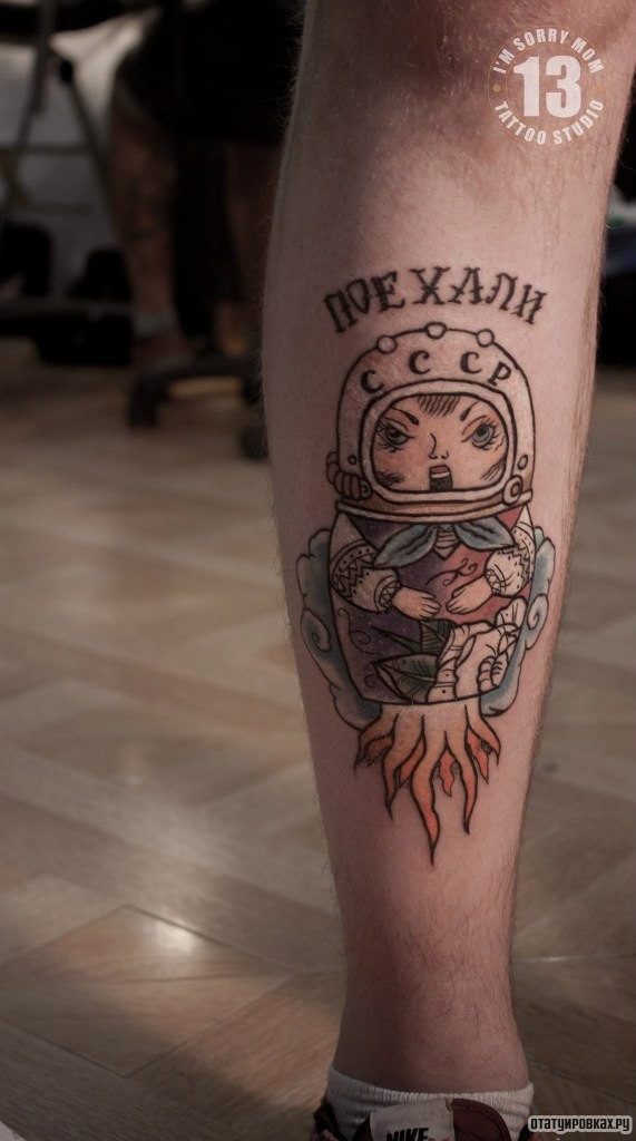Фотография татуировки под названием «Матрешка космонавт ссср, надпись поехали на голени»