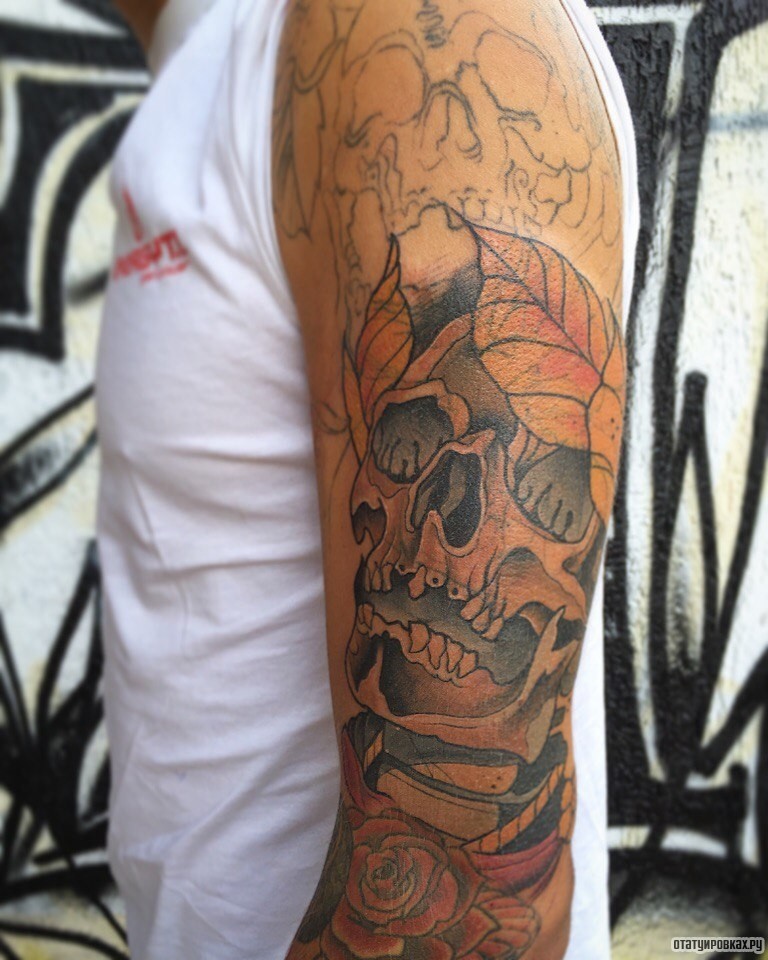 Фотография татуировки под названием «Череп с листьями и розой на плече парня»