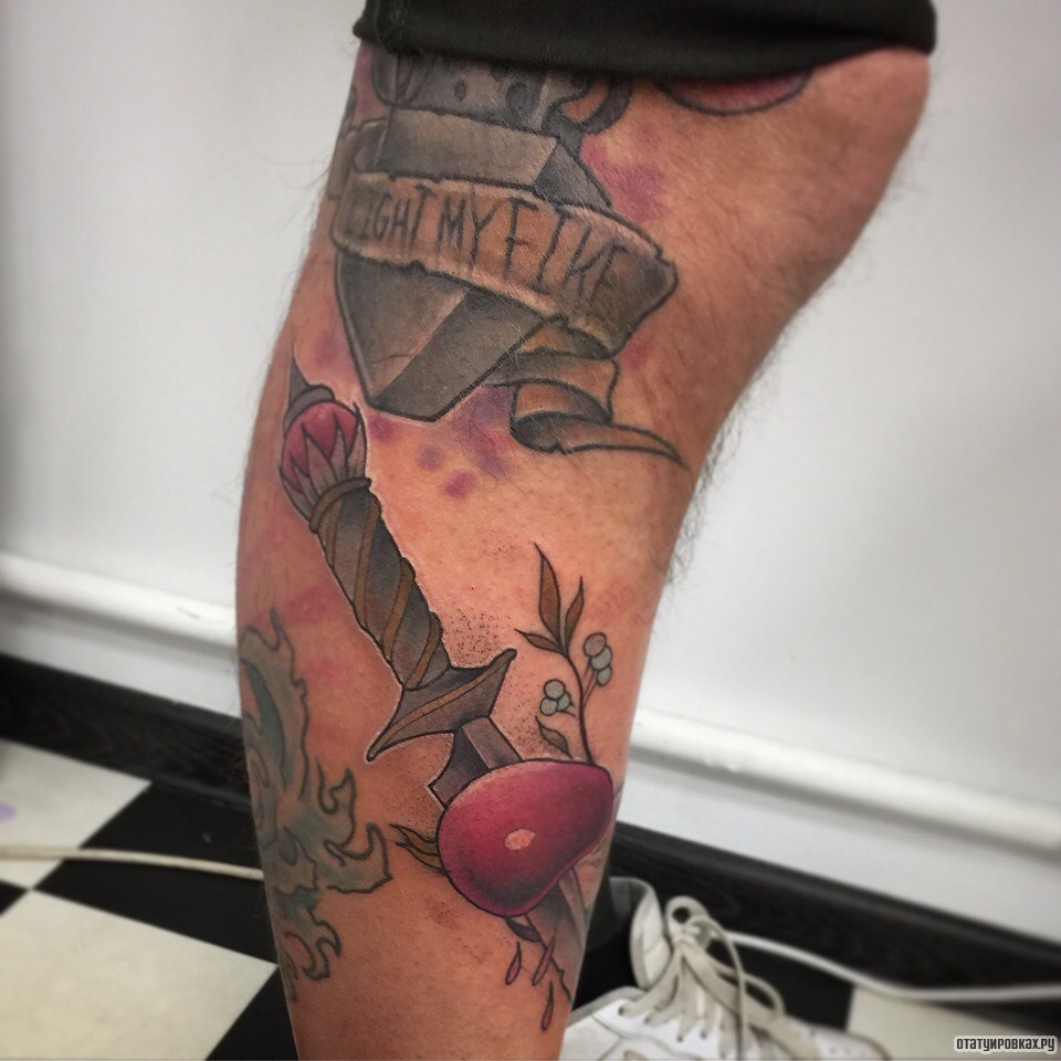 Фотография татуировки под названием «Кинжал с яблоком на голени»
