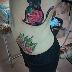 Тату кот с розой в отражении сбоку тела девушки