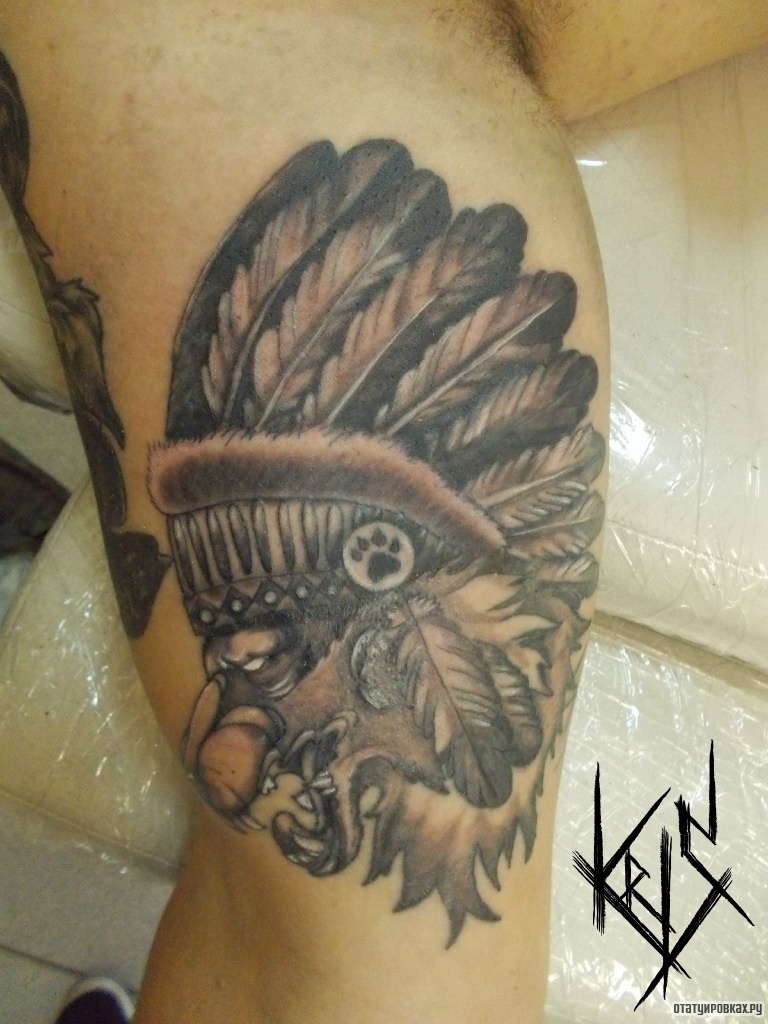 Фотография татуировки под названием «Лев в головном уборе индейцев на бицепсе»