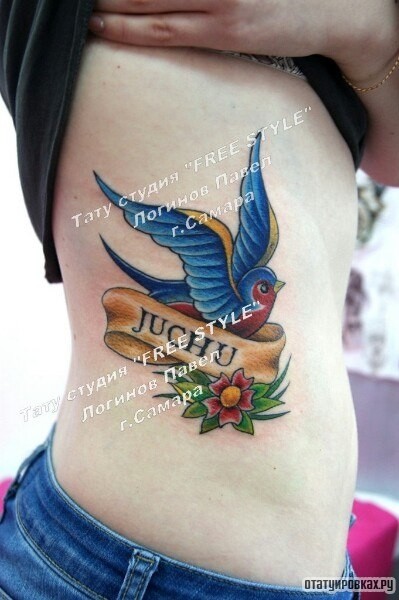 Фотография татуировки под названием «Ласточка с надписью сбоку тела»